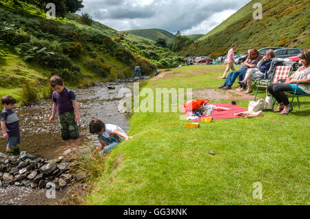 Una vista del mulino di cardatura in Shropshire. I bambini giocano nel flusso. Foto Stock