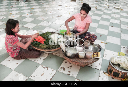 Myanmar donna e bambino la preparazione di cibi a Sagaing Myanmar. Le donne indossano thanaka crema, una lozione viso utilizzati in Myanmar Foto Stock