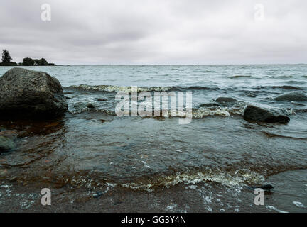 Costa rocciosa nel Golfo di Finlandia e le onde il giorno nuvoloso Foto Stock