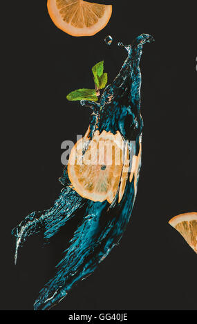 Fettina di limone con uno spruzzo di acqua e foglia di menta Foto Stock