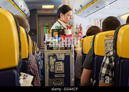 Hostess che serve bevande sul piano di Ryanair da Londra Stansted Aeroporto di Varsavia aeroporto Modlin. Foto Stock