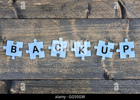 I pezzi del puzzle con Backup di parola Foto Stock