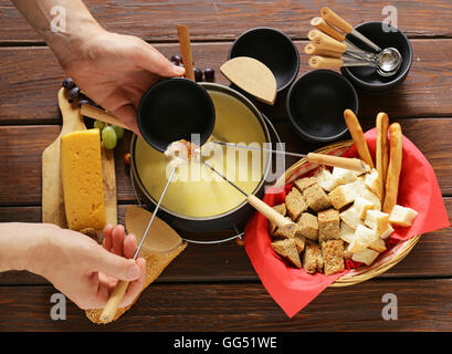 Tradizionale set di utensili per la fonduta, con pane, formaggio e uva Foto Stock