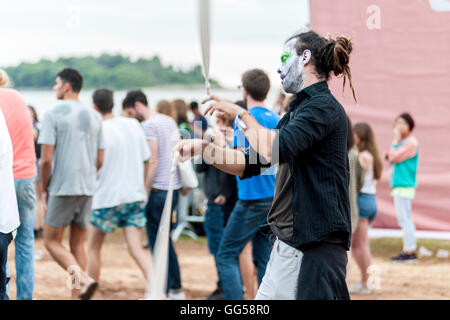 Un giovane con volto dipinto e occhi chiusi sta ballando in un festival musicale in una città balneare di Rovigno in Croazia. Foto Stock
