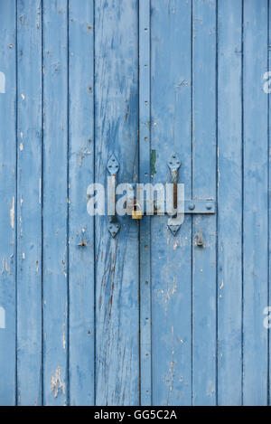 Blue porte verniciate con un lucchetto sulla maniglia della porta Foto Stock