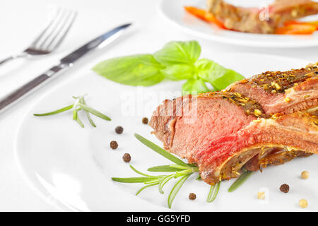 Agnello arrosto costolette di nervatura su una piastra, cena impostazione. Foto Stock