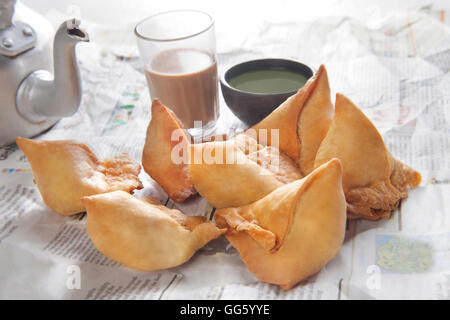 Fresh samosas con chutney e caldo chai pronti per la prima colazione Foto Stock