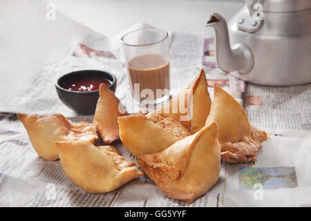 Samosa fresche con ketchup e caldo chai pronti per la prima colazione Foto Stock