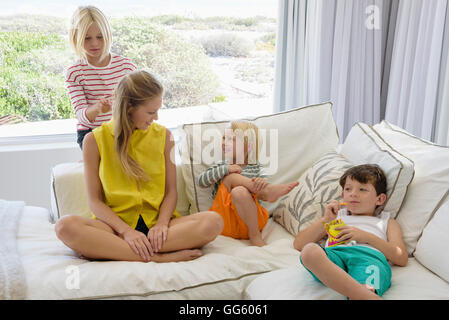 Felice madre e bambini seduti sul divano nel soggiorno Foto Stock