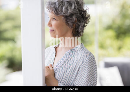 Close-up di una donna appoggiata ad una colonna e pensare Foto Stock