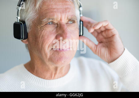 Senior uomo ascoltare musica sulle cuffie Foto Stock