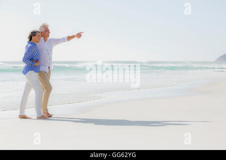 Vista laterale di un giovane godendo sulla spiaggia Foto Stock