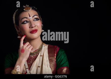 Riflessivo danzatrice Bharatanatyam su sfondo nero Foto Stock