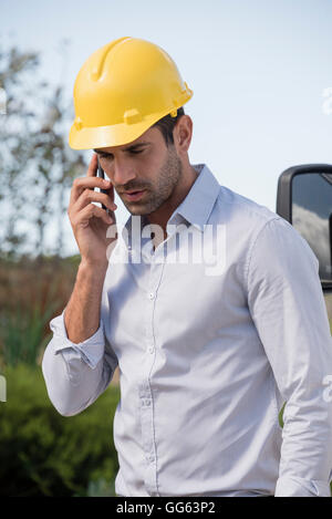 Ingegnere maschio a parlare su un telefono mobile in corrispondenza di un sito Foto Stock