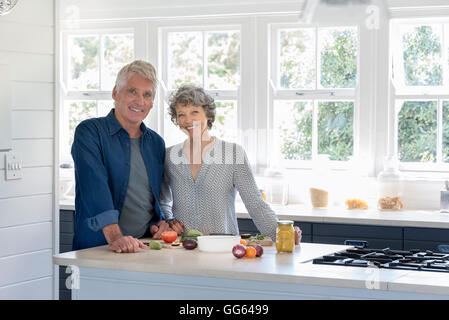Felice coppia senior preparare il cibo in cucina Foto Stock