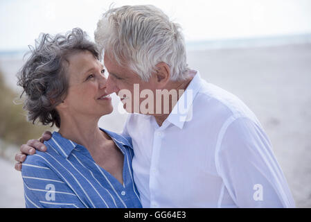 Romantico coppia senior permanente sulla spiaggia Foto Stock