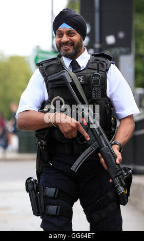 Un Sikh armati funzionario di polizia pattuglia come parte di una operazione di sicurezza vicino alla giunzione di Knightsbridge e Hyde Park Corner, Londra, come Scotland Yard ha annunciato che il primo di 600 ulteriori ufficiali armati sono stati addestrati e operativamente pronto e ha svelato i piani per mettere più tiratori sul servizio pubblico di pattuglia. Foto Stock