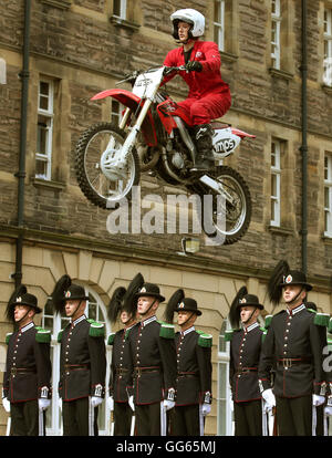 Il PIM Display moto Team salto oltre i membri del team di perforazione da Sua Maestà il Re guardia della Norvegia durante una prova per questo anno la Royal Edinburgh Tattoo militare a Redford caserma di cavalleria di Edimburgo. Foto Stock