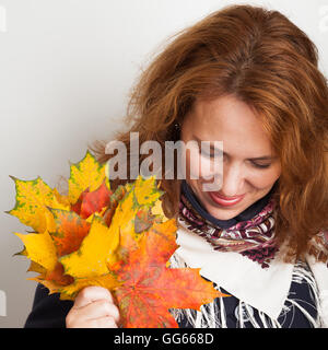 Ritratto di bella sorridente giovane donna con colori d'autunno foglie di acero, foto quadrata Foto Stock