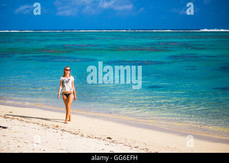 Donna che cammina lungo una spiaggia tropicale, Isola di Rarotonga Isole Cook, South Pacific Pacific Foto Stock