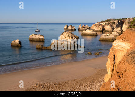 Vista della spiaggia di sabbia fine bagnata dall'oceano blu all'alba, Praia do Alemao, Portimao, distretto di Faro, Algarve, PORTOGALLO Foto Stock