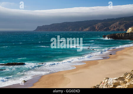 Ocean onde che si infrangono sulla spiaggia di sabbia di Cascais, circondato da scogliere, Costa di Estoril, Lisbona, Portogallo, Europa Foto Stock