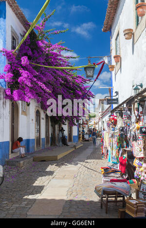 Turisti e negozi nei vicoli tipici dell'antico borgo fortificato di Obidos, Oeste Leiria distretto, Portogallo, Europa Foto Stock