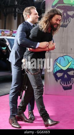 Jason Momoa è abbracciato da Jai Courtney durante la premiere europeo della squadra suicida a l'Odeon nel quadrato di Leicester, Londra. Foto Stock