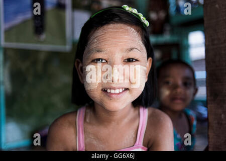 Ritratto di una bella ragazza birmano indossando il tradizionale per il make-up (thanakha) sul suo viso, Dala, Yangon, Myanmar. Foto Stock