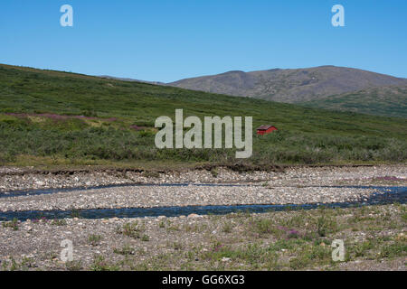 Alaska, Seward Peninsula, Nome. Autostrada Nome-Taylor aka Kougarok strada o Taylor Road. Campagna con vista baia con cabina rosso. Foto Stock