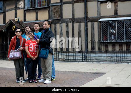 I turisti cinesi tenendo selfie fotografia al di fuori di William al luogo di nascita di Shakespeare, Stratford-upon-Avon, Warwickshire, Regno Unito Foto Stock