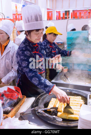 Lo chef prepara cibi da strada nella città vecchia, Shanghai, Cina Foto Stock