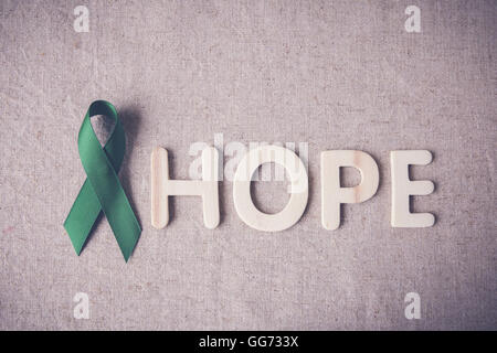 Nastro Verde con la speranza di parola in legno, cancro consapevolezza, fegato, cancro del rene consapevolezza Foto Stock