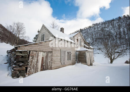 Vecchia casa abbandonata nel paesaggio invernale Foto Stock