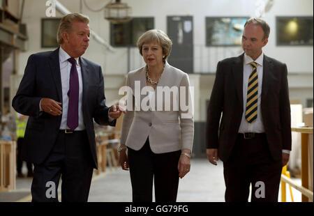 È sotto embargo per 0001 Giovedì 4 Agosto il Primo Ministro Theresa Maggio con Martek Managing Director Derek Galloway (sinistra) e Croydon Central MP Gavin Barwell (a destra) durante la sua visita a Martek falegnameria costruttori in New Addington, Surrey. Foto Stock