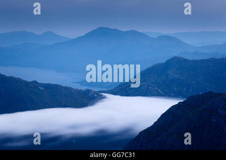 Una banda di nubi a bassa sospensione intrucia i bordi ruvidi di Knoydart all'alba, visto dalla cima di Sgurr na Ciche Foto Stock