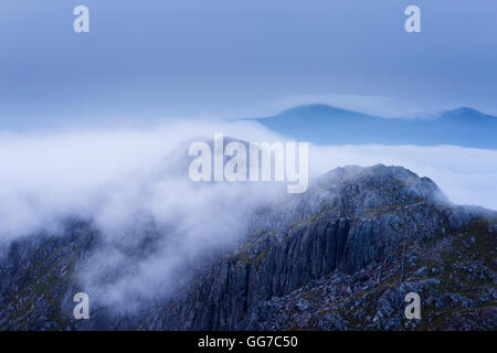 Un vecchio dyke acceso fino la cresta di Garbh Chioch Mhor mentre un inversione rulli sopra il suo vertice Foto Stock