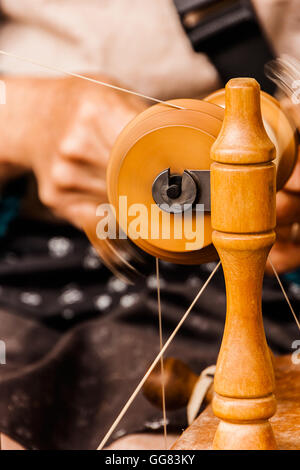 Dodo la filatura del cotone di forma tradizionale su un artigiani di mercato. Foto Stock