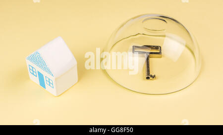 Preferenze di assicurazione della vostra casa, uno in miniatura della casa di ceramica non è protetto e la chiave della casa protetta Foto Stock
