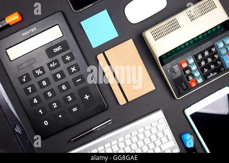 Vista di uno spazio ufficio con strumenti di business dal di sopra su sfondo nero Foto Stock