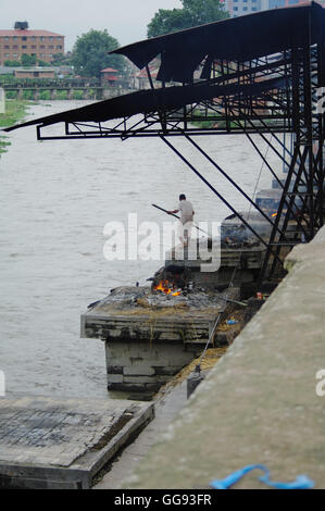 KATHMANDU,NP circa agosto 2012 - Uomo burning cadavere nel tempio di Pashupatinath circa agosto 2012 a Kathmandu. Il Pashupatinath Te Foto Stock