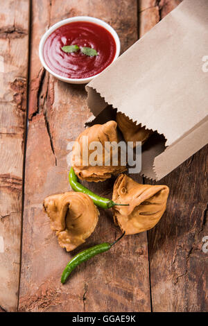 Samosa snack di ketchup e tè caldo, fresco samosas con ketchup e caldo chai pronti per la prima colazione Foto Stock