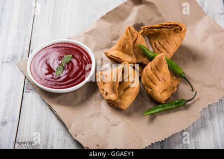 Samosa snack di ketchup e tè caldo, fresco samosas con ketchup e caldo chai pronti per la prima colazione Foto Stock