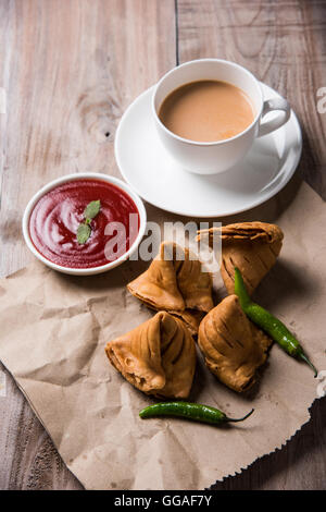 Samosa snack di ketchup e tè caldo, fresco samosas con ketchup e caldo chai pronti per la prima colazione Foto Stock