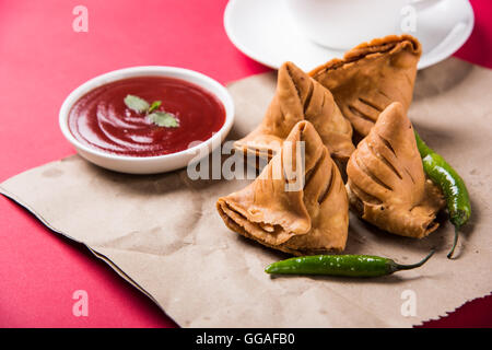 Samosa snack di ketchup e tè caldo, fresco samosas con ketchup e caldo chai pronti per la prima colazione Foto Stock