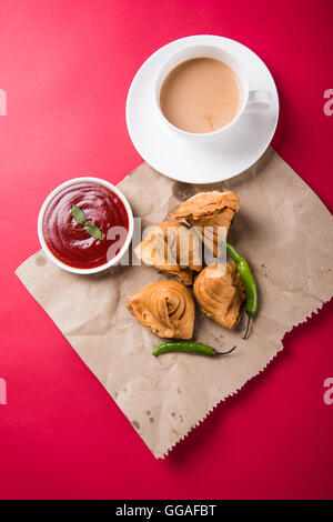 Samosa snack di ketchup e tè caldo, fresco samosas con ketchup e caldo chai pronti per la prima colazione Foto Stock