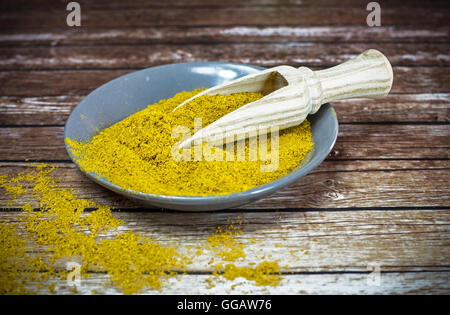 Piastra piccola di curry in polvere con il cucchiaio di legno Foto Stock