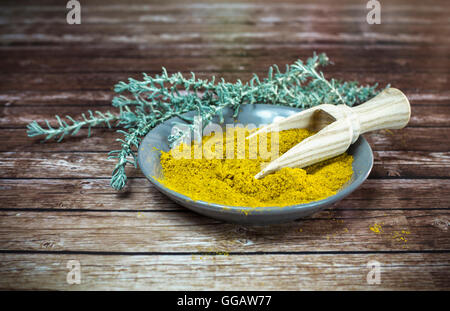 Piastra piccola di curry in polvere con il cucchiaio di legno Foto Stock