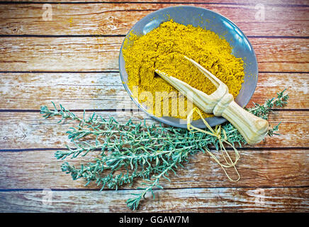 Piastra piccola di curry in polvere con il cucchiaio di legno Foto Stock