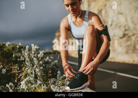 Donna che indossa scarpe da running all'aperto su strada in campagna. concetto di fitness e stile di vita sano. Foto Stock